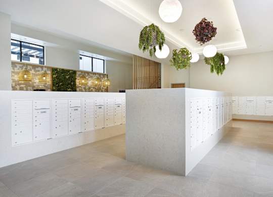 A white reception desk with a white wall behind it.