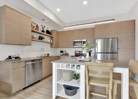A modern kitchen with wooden cabinets and stainless steel appliances.