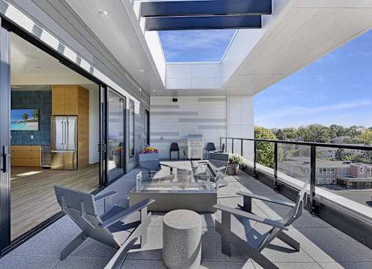A modern balcony with a table and chairs overlooking a cityscape.