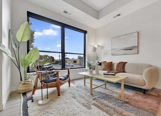 A living room with a couch, chair, and a large window.