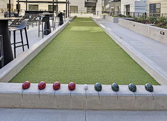 A miniature golf course is located in the courtyard of a modern apartment complex.