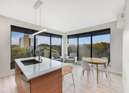 A modern kitchen with a large island and a view of the city.