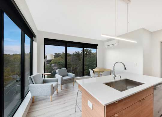 A modern kitchen with a large island and a view of the outdoors.