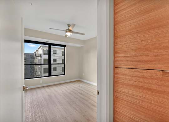 A room with a ceiling fan and a wooden door.