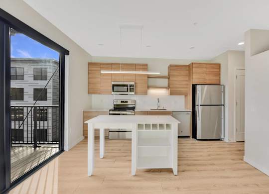 A modern kitchen with a white table and a refrigerator.