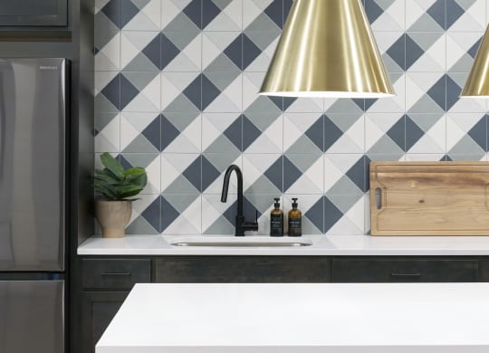 a kitchen with black and white tiles and a gold pendant light