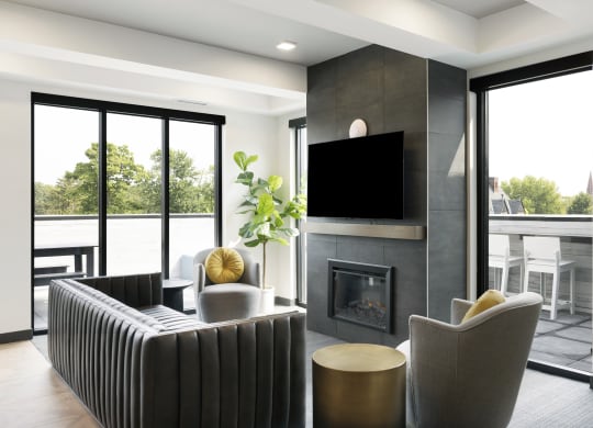a living room with a fireplace and chairs and a television