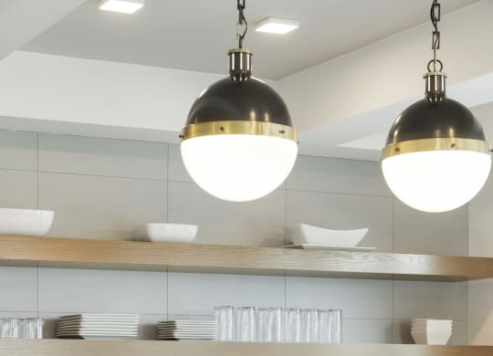 a kitchen with white cabinets and stainless steel appliances and lights