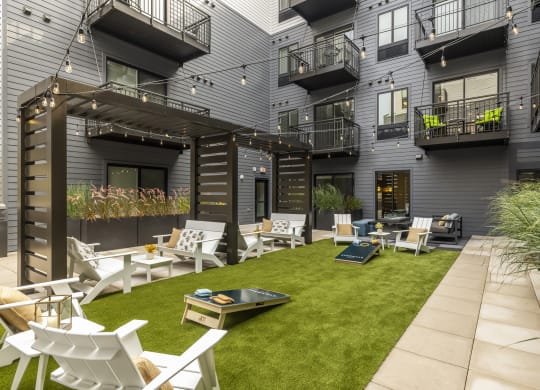 a courtyard with chairs and tables and grass