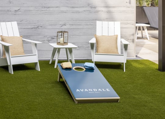 a group of white chairs around a coffee table on the grass