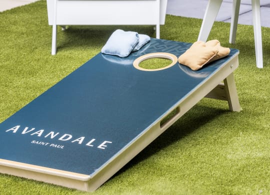 a white chair and a table with a blue rug on the grass