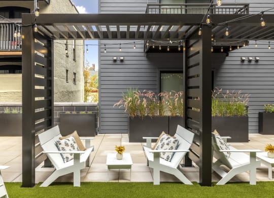 a group of white lounge chairs and tables on a patio