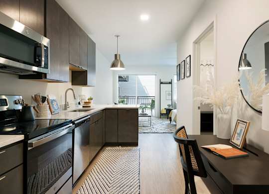 A modern kitchen with dark wood cabinets and black countertops.