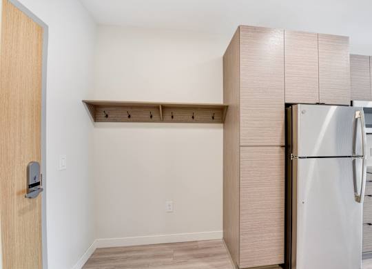 A kitchen with a refrigerator and a door.