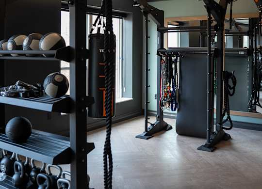 A gym with a weight rack and a mirror.