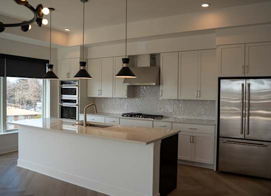 A modern kitchen with a large island and stainless steel appliances.