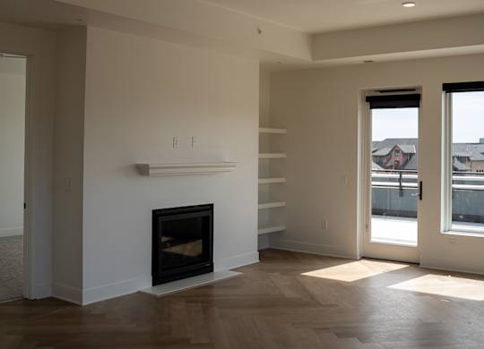 A modern living room with a fireplace and wood flooring.