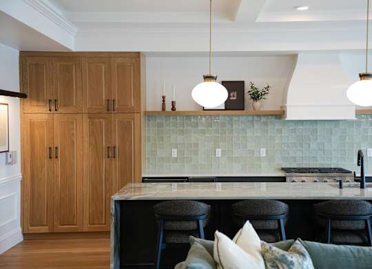 A kitchen with wooden cabinets and a marble countertop.