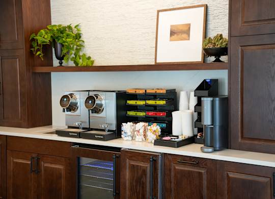 A kitchen with brown cabinets and a coffee machine on the counter.