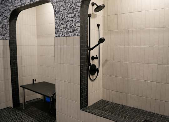 A bathroom with a shower and a bench.
