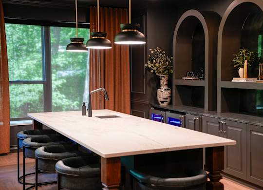 A modern kitchen with a large island and bar stools.