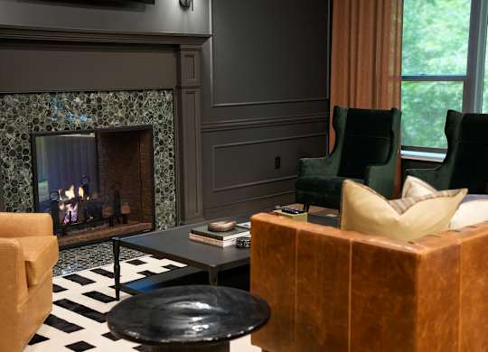 A living room with a fireplace and a black and white checkered floor.