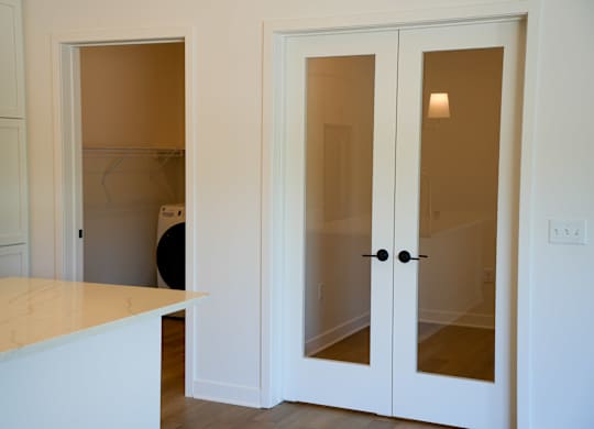 A kitchen with white cabinets and a white countertop.
