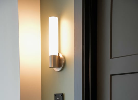 A black door with a silver handle and a black plate with the number 218 on it.