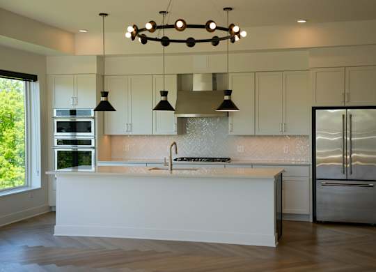 A modern kitchen with a large island and stainless steel appliances.