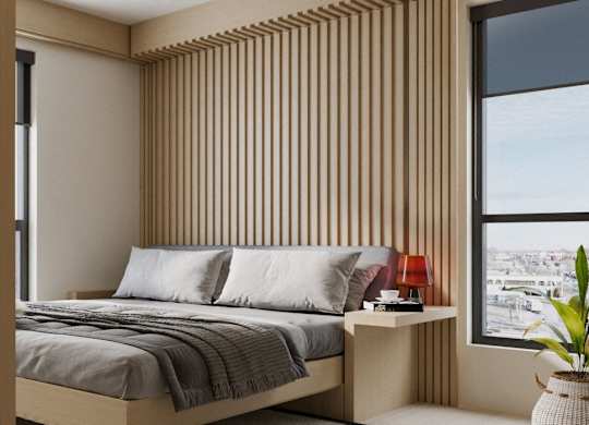 A bedroom with a bed, a nightstand, and a large window with a view of the city.