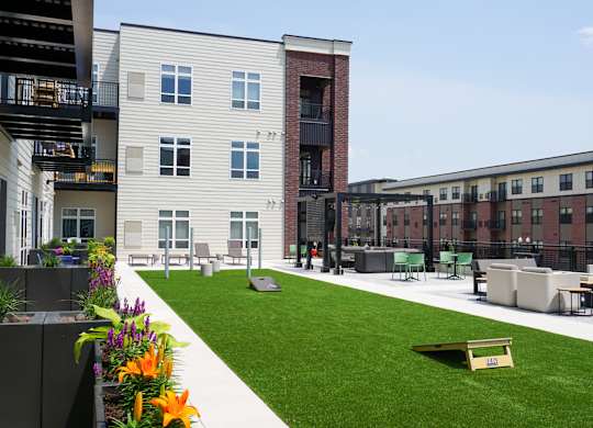 A grassy area with benches and a building in the background.