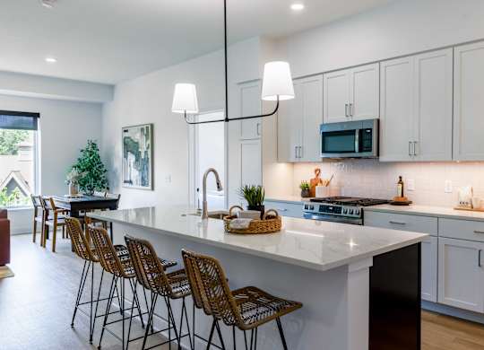 A modern kitchen with white cabinets and a large island.