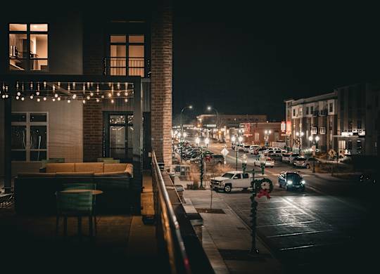 A city street at night with cars and buildings.
