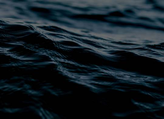 A close up of dark blue water with ripples.