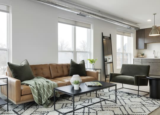 a living room with a brown leather couch and a black and white rug