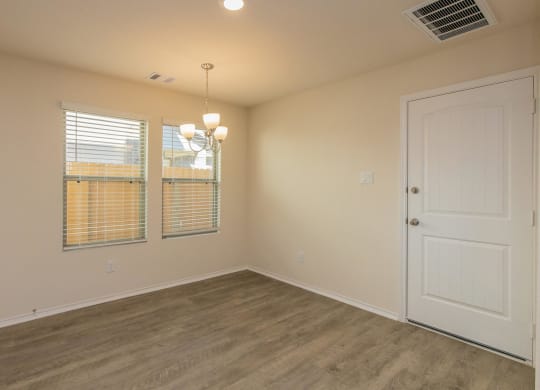 a bedroom with a door and two windows at The Village at Granger Pines, Texas, 77302