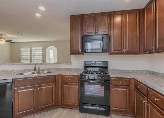 a kitchen with a stove top oven next to a sink at The Village at Granger Pines, Texas, 77302
