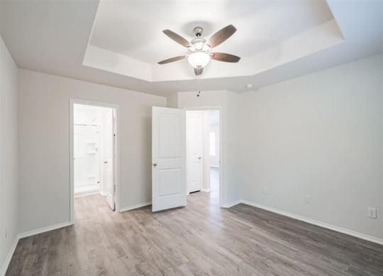 a bedroom with hardwood floors and a ceiling fan at The Village at Granger Pines, Conroe, TX 77302