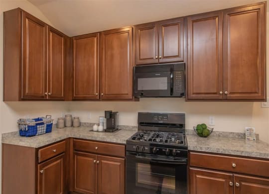 a kitchen with a stove top oven next to a microwave at The Village at Granger Pines, Conroe Texas