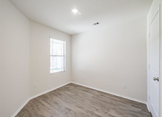 an empty room with a window and a door at The Village at Granger Pines, Conroe Texas