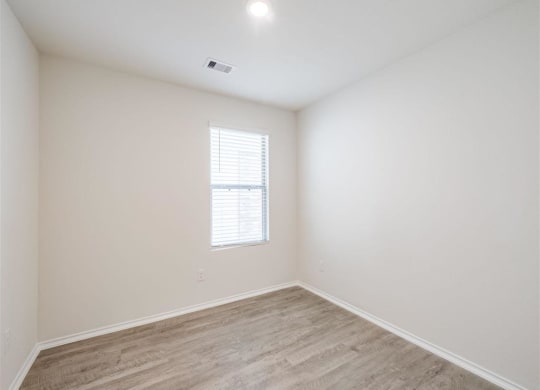 a bedroom with white walls and a window at The Village at Granger Pines, Conroe, TX