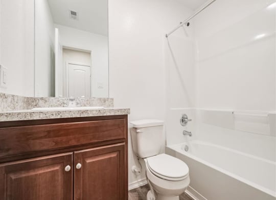 a bathroom with a toilet sink and bathtub at The Village at Granger Pines, Texas, 77302