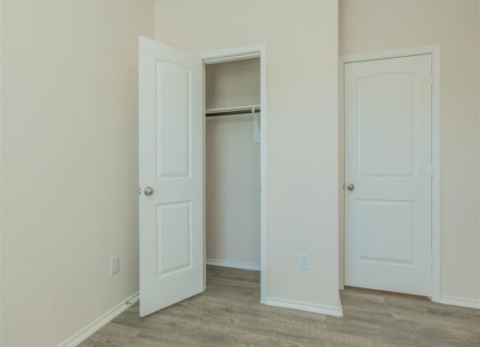 a bedroom with two doors and a closet at The Village at Granger Pines, Conroe