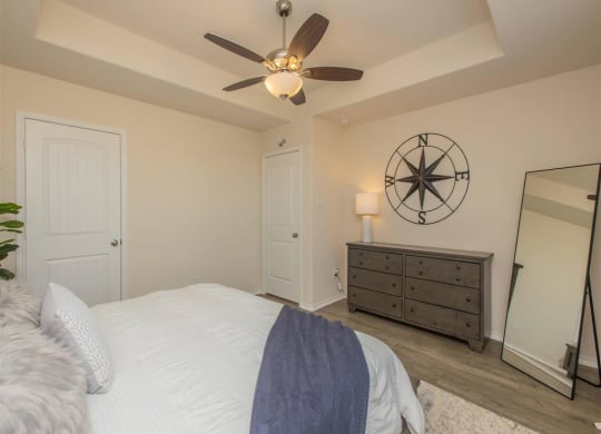 a bedroom with a large bed and a ceiling fan at The Village at Granger Pines, Conroe, TX