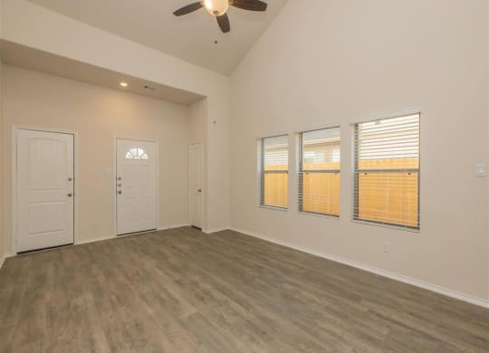 a bedroom with a ceiling fan and three windows at The Village at Granger Pines, Conroe