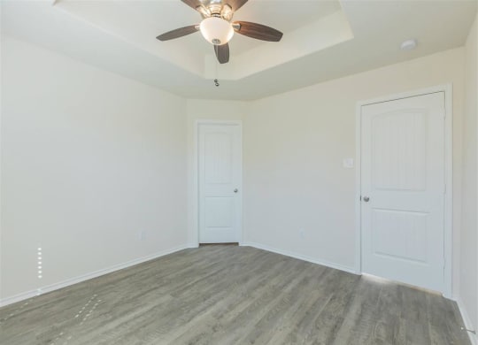 a bedroom with white walls and a ceiling fan at The Village at Granger Pines, Conroe Texas