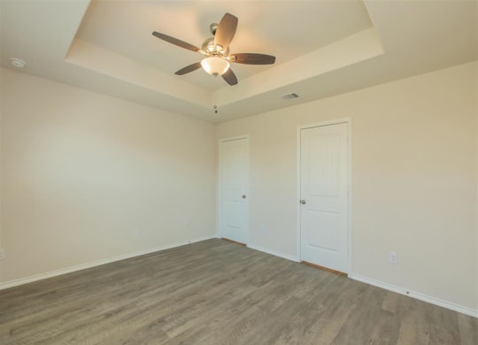 a bedroom with a ceiling fan and a door to a closet at The Village at Granger Pines, Conroe