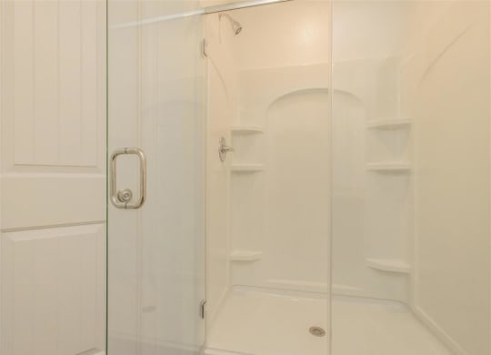 a white bathroom with a glass shower door at The Village at Granger Pines, Conroe, TX