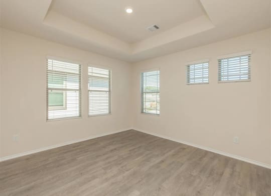 an empty room with white walls and a coffered ceiling at The Village at Granger Pines, Conroe, TX 77302