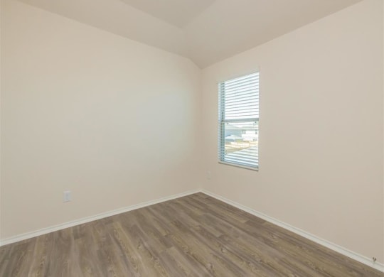 an empty room with white walls and a window at The Village at Granger Pines, Conroe, TX